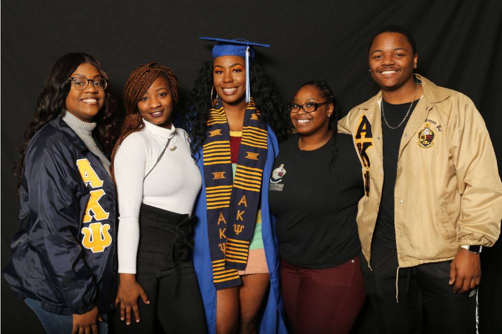 four lakers pose with a soon to be graduate